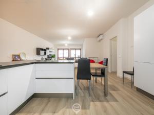 a kitchen with white cabinets and a table and chairs at Giulia's House in Oristano +20 photos