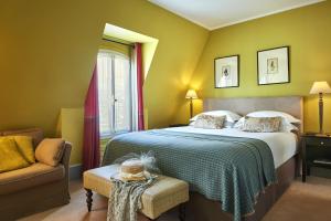 a bedroom with a bed and a chair and a window at Hôtel Sainte-Beuve in Paris