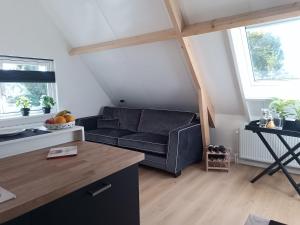 a living room with a couch and a table at Top appartement Short Stay in mooie omgeving Kortenhoef. in Kortenhoef