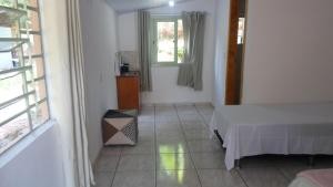 Schlafzimmer mit einem Bett und einem Fenster in der Unterkunft Kantinho da Serra in Nova Petrópolis