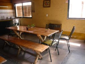 una mesa de madera y sillas en la cocina en Pasos Andinos B&B en Eugenio Bustos