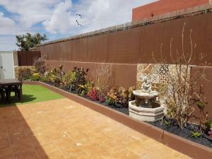 un giardino con panchina e tavolo accanto a un muro di Apartamento rural zona céntrica isla a Puerto del Rosario