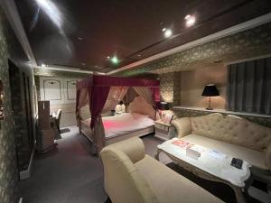 um quarto com uma cama e um sofá num quarto em Hotel Pharaoh-Adult Only em Sapporo