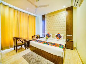 a bedroom with a bed and a desk and a chair at FabHotel Diamond Zirakpur in Zirakpur