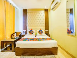 a bedroom with a bed and a desk in a room at FabHotel Diamond Zirakpur in Zirakpur
