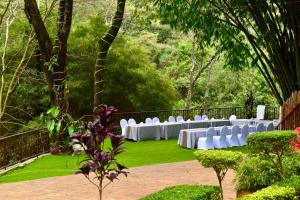 a wedding reception in a garden with white chairs at West Wood Hotel in Nairobi