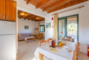 kuchnia i salon z białym stołem i krzesłami w obiekcie Spiros Beach Villa w mieście Frangokastello