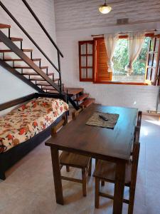 Habitación con mesa, cama y escalera. en Departamentos corrientes en Santa Rosa de Calamuchita