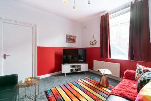 ein Wohnzimmer mit roten Wänden und einem Flachbild-TV in der Unterkunft Jesouth Homey 5 Bedrooms 9 Beds - Contractors - Leisure - Central Location in Hull