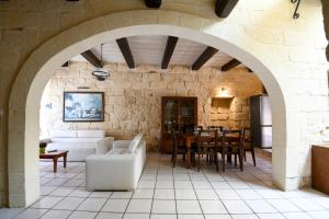 einen Torbogen in einem Zimmer mit einem Tisch und Stühlen in der Unterkunft Ta'Peppa in Xagħra