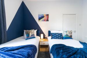2 Betten in einem blau-weißen Zimmer in der Unterkunft Jesouth Homey 5 Bedrooms 9 Beds - Contractors - Leisure - Central Location in Hull