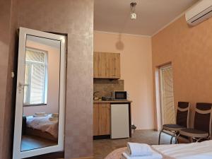 1 dormitorio con 1 cama, cocina y espejo en Guest Rooms Exotic, en Pazardzhik