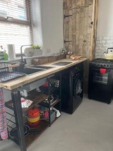 a kitchen with a sink and a washing machine at Honestone Street hideaway in blissful Bideford in Bideford