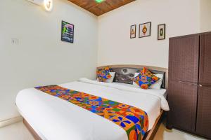 a bedroom with a bed with a colorful comforter at FabExpress Vardhan Executive in Pune