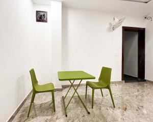 una mesa verde y 2 sillas en una habitación en Radha Krishna Bhawan, Homestay en Vrindāvan