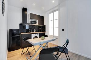 uma cozinha com mesa e cadeiras num quarto em Appartement 4 personnes aux Portes de Paris em Saint-Denis