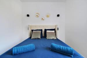 um quarto com uma cama com lençóis e almofadas azuis em Appartement 4 personnes aux Portes de Paris em Saint-Denis
