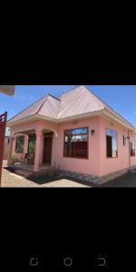 a small pink house with a roof at ZIMBE HOST Apartment in Arusha