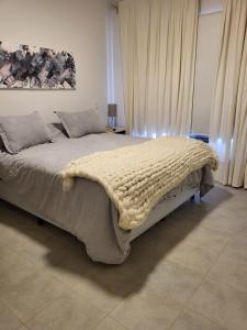 Un dormitorio con una cama grande con una manta. en El Castaño Apart en Potrerillos