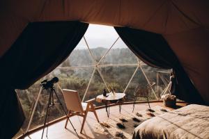 a view from inside a tent with a table and chairs at World Peaks Hotel in Richka