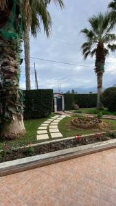 a garden with palm trees and a walkway at Patras Blue Suite in Patra
