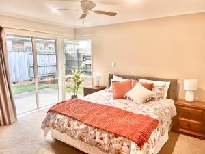 a bedroom with a bed and a window at Home In On Family - 230m from Papamoa Beach in Papamoa