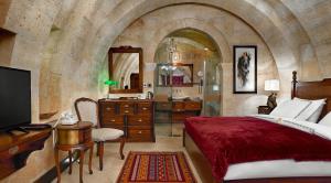 ein Schlafzimmer mit Bett und ein Badezimmer mit Waschbecken in der Unterkunft Seraphim Cave Suites & SPA in Ürgüp