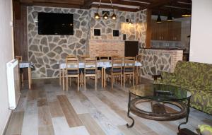 a dining room with a table and chairs and a stone wall at Casa Rural "La Cerecera" in Los Navalucillos