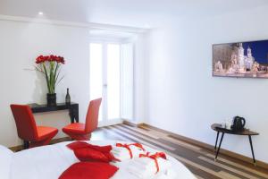 ローマにあるハブ ナヴォーナのベッドルーム1室(赤い枕と椅子2脚付きのベッド1台付)