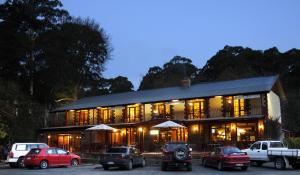 Black Spur Inn في Narbethong: مبنى كبير فيه سيارات تقف امامه