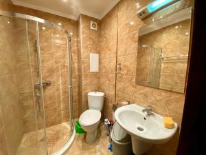 a bathroom with a shower and a toilet and a sink at Green Paradise Deluxe Apartments in Primorsko