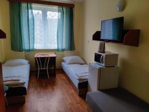 a small room with two beds and a tv at Rekreačné zariadenie Javorinka in Gerlachov