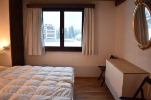 a bedroom with a large bed and a window at Parc Anemona (274 Ba) in Lenzerheide