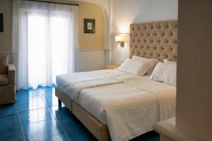 Un dormitorio con una cama grande y una ventana en Arathena Rocks Hotel, en Giardini Naxos