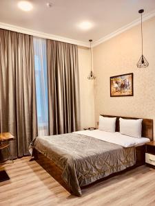 een slaapkamer met een bed en een groot raam bij Moss Art Boutique Hotel in Baku