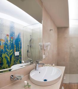 a bathroom with a sink and a shower at Arathena Rocks Hotel in Giardini Naxos