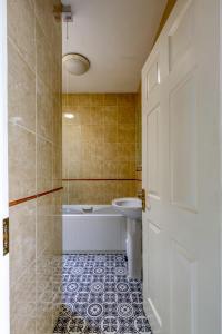 a bathroom with a tub and a sink and a door at The Herons Rest Boutique Accommodation in Galway