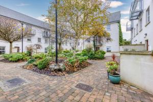 a courtyard with trees and plants in front of a building at The Herons Rest Boutique Accommodation in Galway