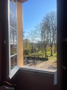 una ventana abierta con vistas a un parque en Suite le Quervalat dans magnifique bastide 18eme en Aix-en-Provence