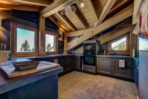 cocina grande con paredes de madera y techo de madera en Luxurious Ski-in Ski-out Duplex on Ski Slope, en Courchevel
