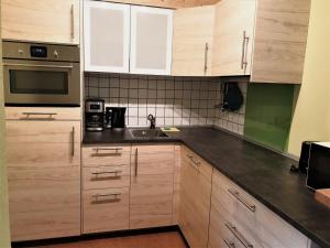 eine Küche mit Holzschränken und einem Waschbecken in der Unterkunft Ferienwohnung Bär in Vohenstrauß