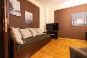 a living room with a couch and a tv at Delmare Posidonio Apartment in Thessaloniki
