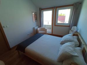 a bedroom with a large bed and a window at Ático con vistas a la ría de Arosa in Rianjo