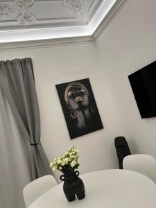 a white table with a vase of flowers on it at La Maison del Bell'Antonio - Catania downtown in Catania