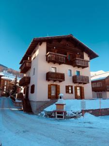 duży budynek z śniegiem na ziemi przed nim w obiekcie Casa Norberto w Livigno