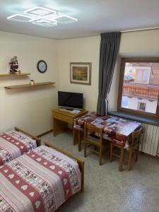 a room with two beds and a desk with a computer at Casa Norberto in Livigno