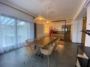 comedor con mesa de madera y sillas en Angyal Villa, en Rátka