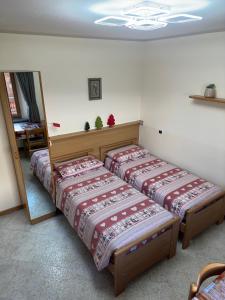 a bedroom with two beds and a mirror at Casa Norberto in Livigno