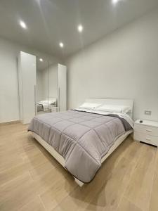 1 dormitorio blanco con 1 cama grande y espejo en B&B MANFREDI en Foggia