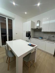 a white kitchen with a table and two chairs at B&B MANFREDI in Foggia